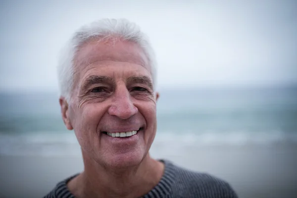 Uomo anziano sorridente alla spiaggia — Foto Stock