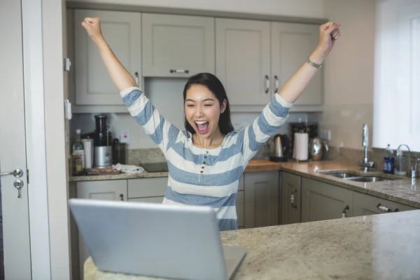 Kvinna med en laptop i köket — Stockfoto