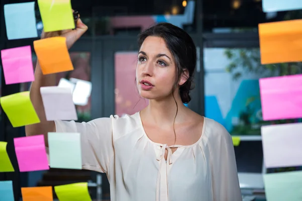 Donna d'affari che scrive sulla nota appiccicosa — Foto Stock