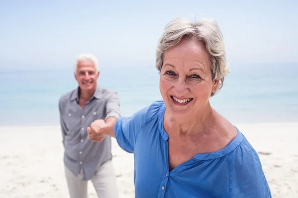 Senior paar die hand op strand — Stockfoto