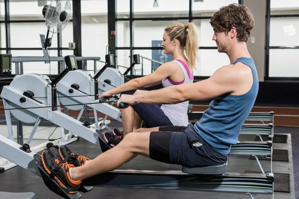 Man and woman on rowing machine - Stock Image - Everypixel