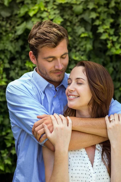 Lächelndes Paar umarmt sich im Vorgarten — Stockfoto