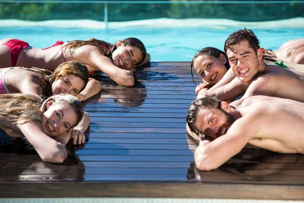 Group of happy friends on wooden deck near pool — Stock Photo, Image