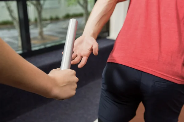 Athlete passing baton to partner — Stock Photo, Image
