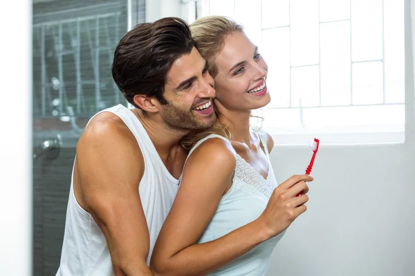 Pareja abrazándose mientras se cepilla los dientes — Foto de Stock