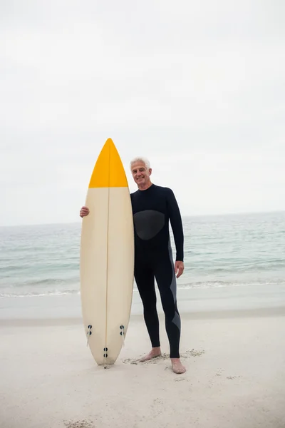 서핑 보드를 들고 잠수복에 수석 남자 — 스톡 사진