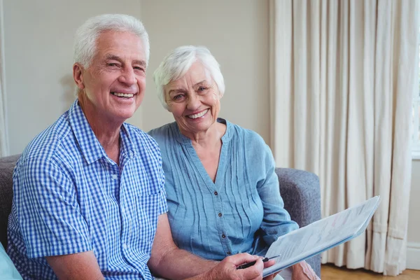 Feliz pareja de ancianos con facturas — Foto de Stock