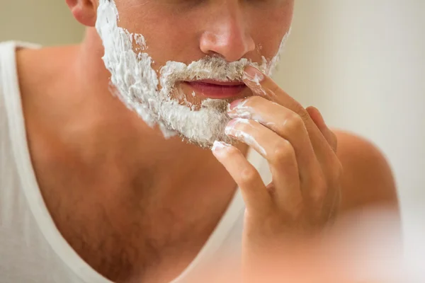 Homem aplicando espuma de barbear — Fotografia de Stock