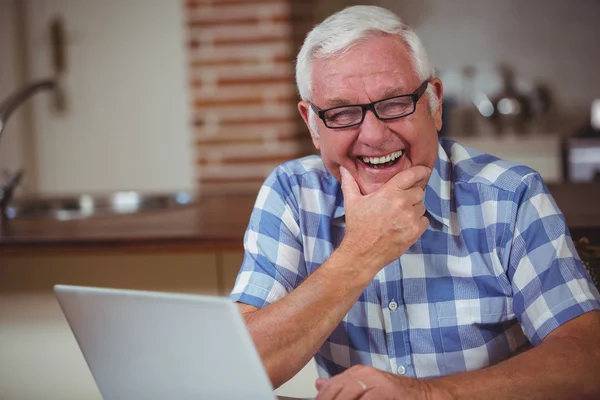 Lachende senior man met laptop — Stockfoto