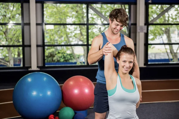 Tränare hjälpa kvinnan med stretching motion — Stockfoto