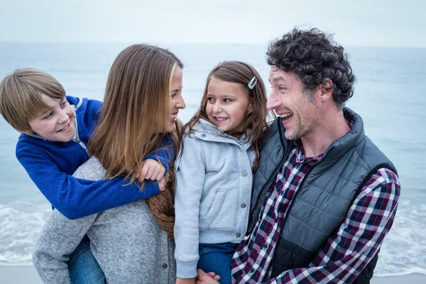 Padres disfrutando con niños en la orilla — Foto de Stock