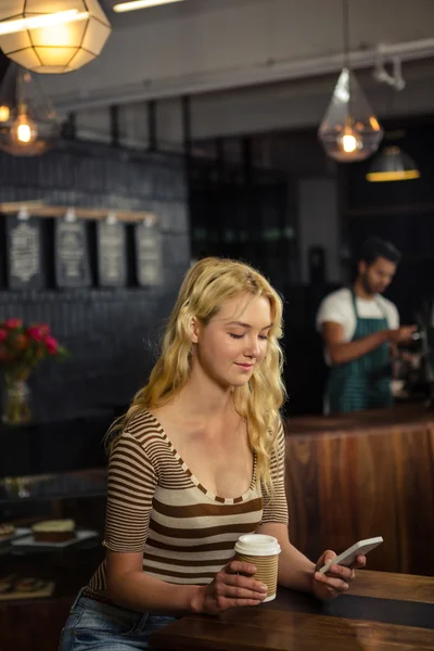 Donna che beve caffè e utilizza smartphone — Foto Stock