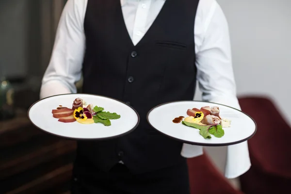 Retrato del camarero presentando comidas — Foto de Stock