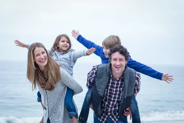 Padres felices llevando hijos — Foto de Stock