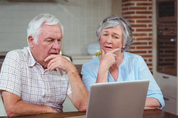 Tankeväckande äldre par med laptop — Stockfoto