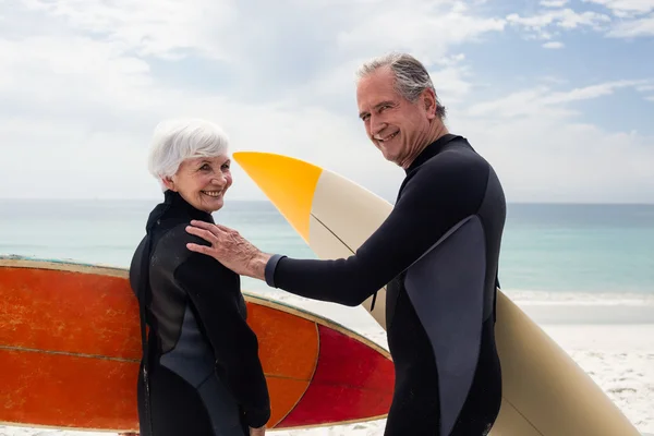 Üst düzey çift sahilde sörf tahtaları holding — Stok fotoğraf