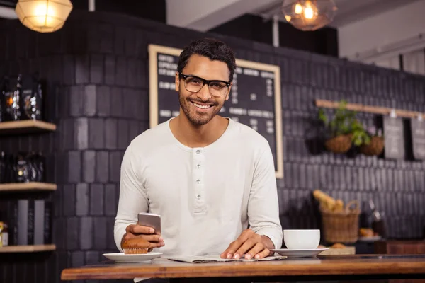 Man met smartphone en krant — Stockfoto