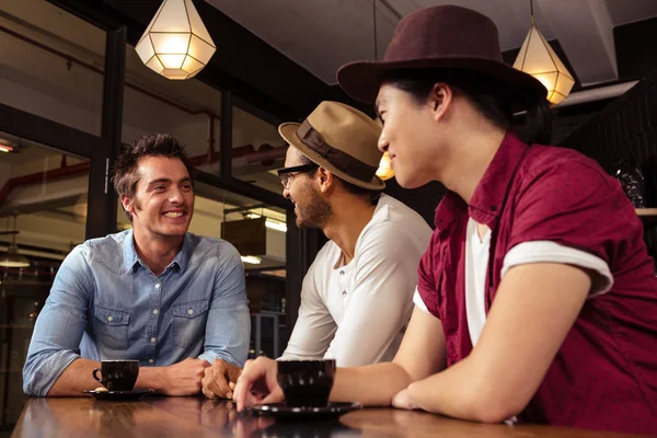 Amigos sentados en una mesa — Foto de Stock