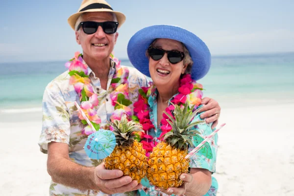 Äldre par hålla ananas cocktails — Stockfoto