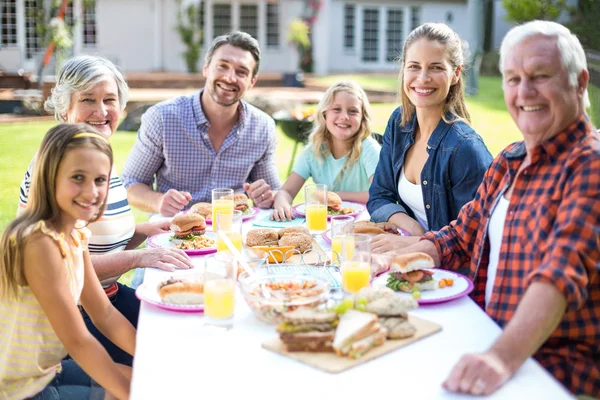 Glad familj sitter vid bord — Stockfoto