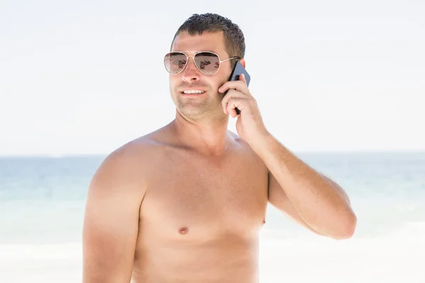 Man op de telefoon op het strand — Stockfoto