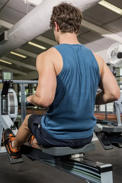 Man working out on rowing machine — Stock Photo, Image