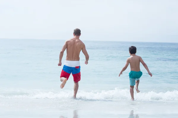 父と息子のビーチで実行しています。 — ストック写真