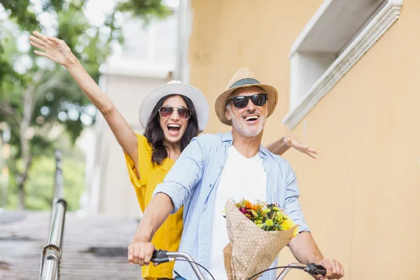 Uomo in bicicletta con donna eccitata — Foto Stock