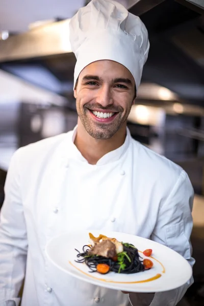 Knappe chef-kok presenteert maaltijd — Stockfoto