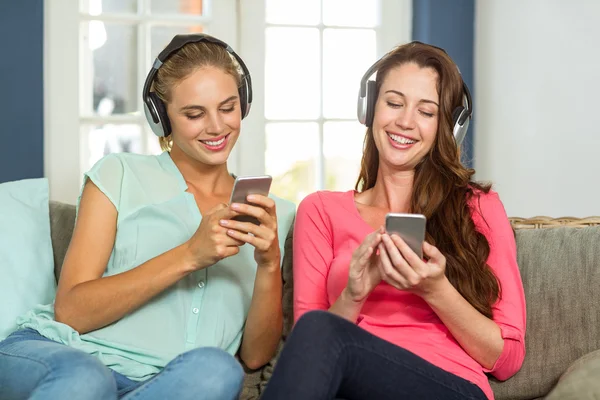 Female friends listening to music — Stock Photo, Image