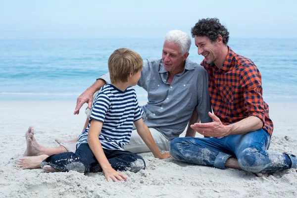 Familia descansando en la orilla del mar — Foto de Stock