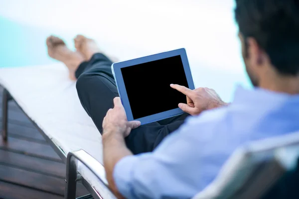 Homme utilisant une tablette près de la piscine — Photo