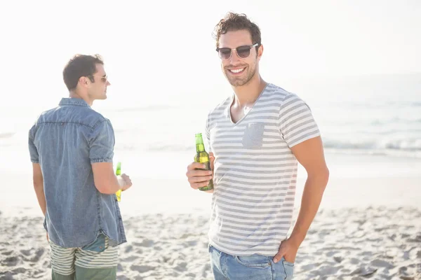Друзья пьют пиво на пляже — стоковое фото