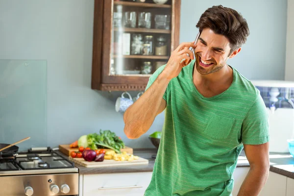 Uomo che parla al telefono in cucina — Foto Stock