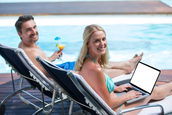 Pareja sentada cerca de la piscina — Foto de Stock