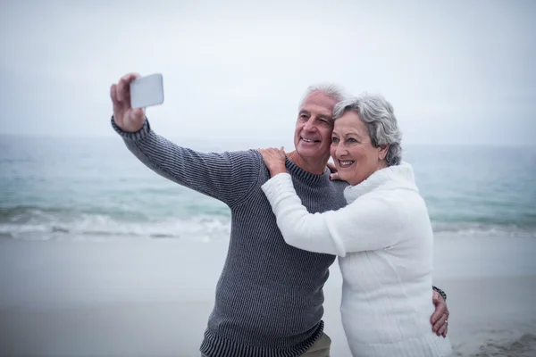 Coppia anziana scattare selfie sulla spiaggia — Foto Stock