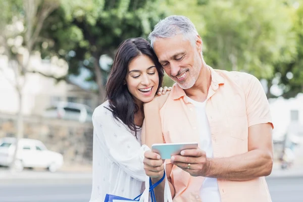 Smiling couple using phone — Stock Photo, Image