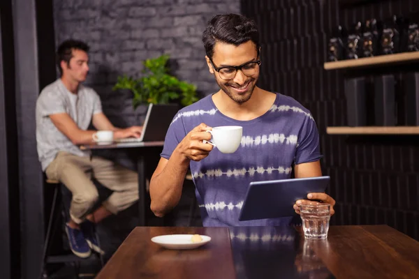 Homme utilisant une tablette et buvant du café — Photo