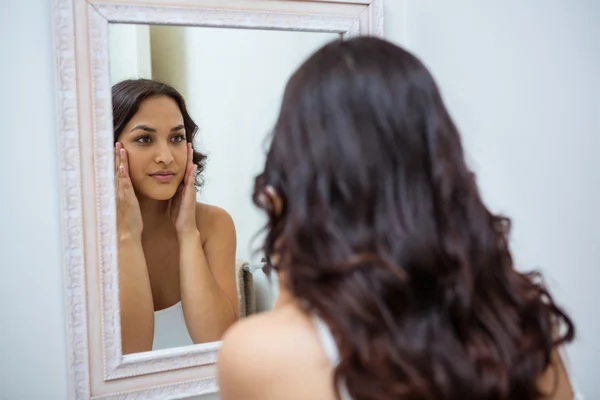 Woman checking skin in bathroom — Stock Photo, Image