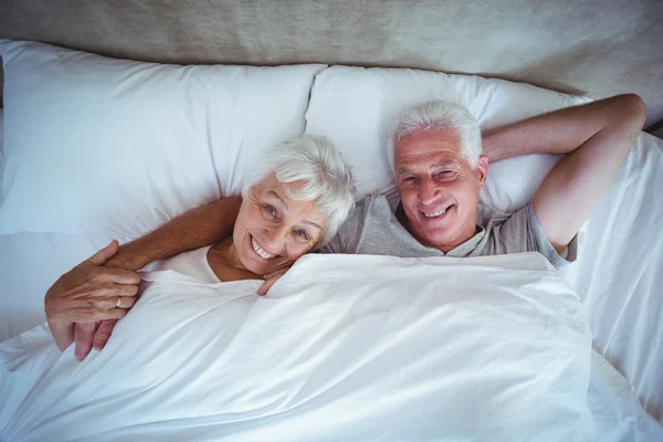 Człowiek z żoną leżąc na łóżku — Zdjęcie stockowe
