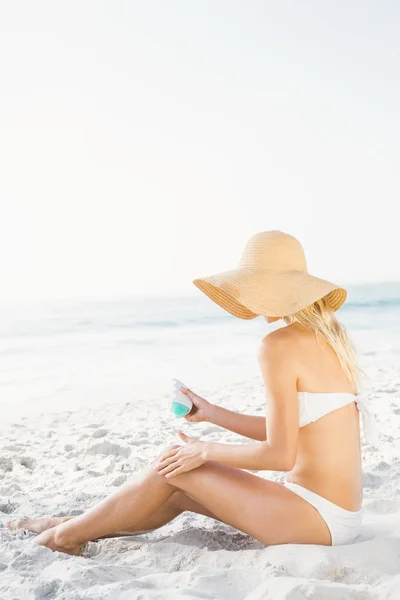 Mulher loira aplicando protetor solar — Fotografia de Stock