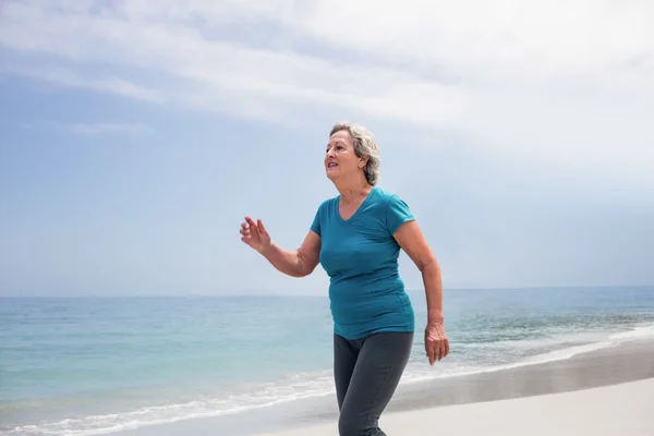Mujer mayor corriendo en la playa — Foto de Stock