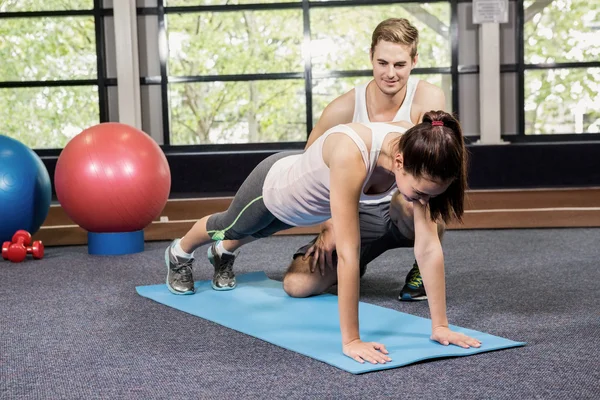 Entrenador ayudando a la mujer con flexiones — Foto de Stock