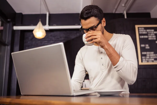 Homem usando um laptop e beber café — Fotografia de Stock