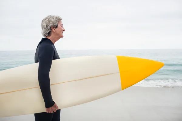 Femme âgée tenant une planche de surf — Photo