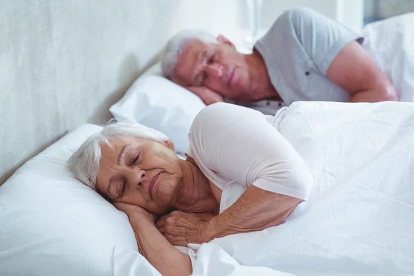 Senior paar slapen op bed — Stockfoto