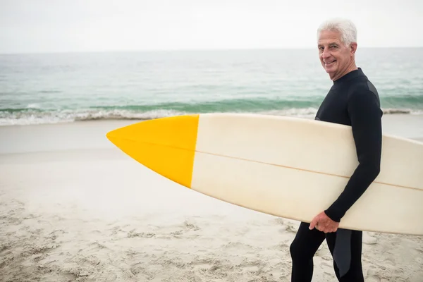 Homme en combinaison tenant planche de surf — Photo