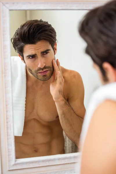 Человек проверяет свою кожу в ванной комнате — стоковое фото
