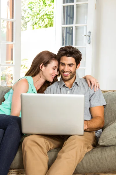 Feliz pareja joven utilizando el ordenador portátil —  Fotos de Stock