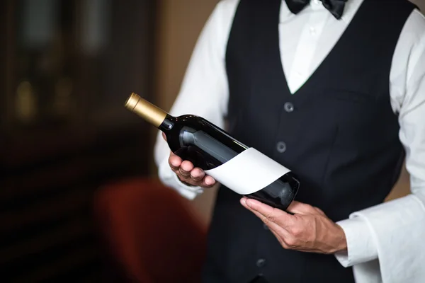 Servitören lägger fram rött vin — Stockfoto